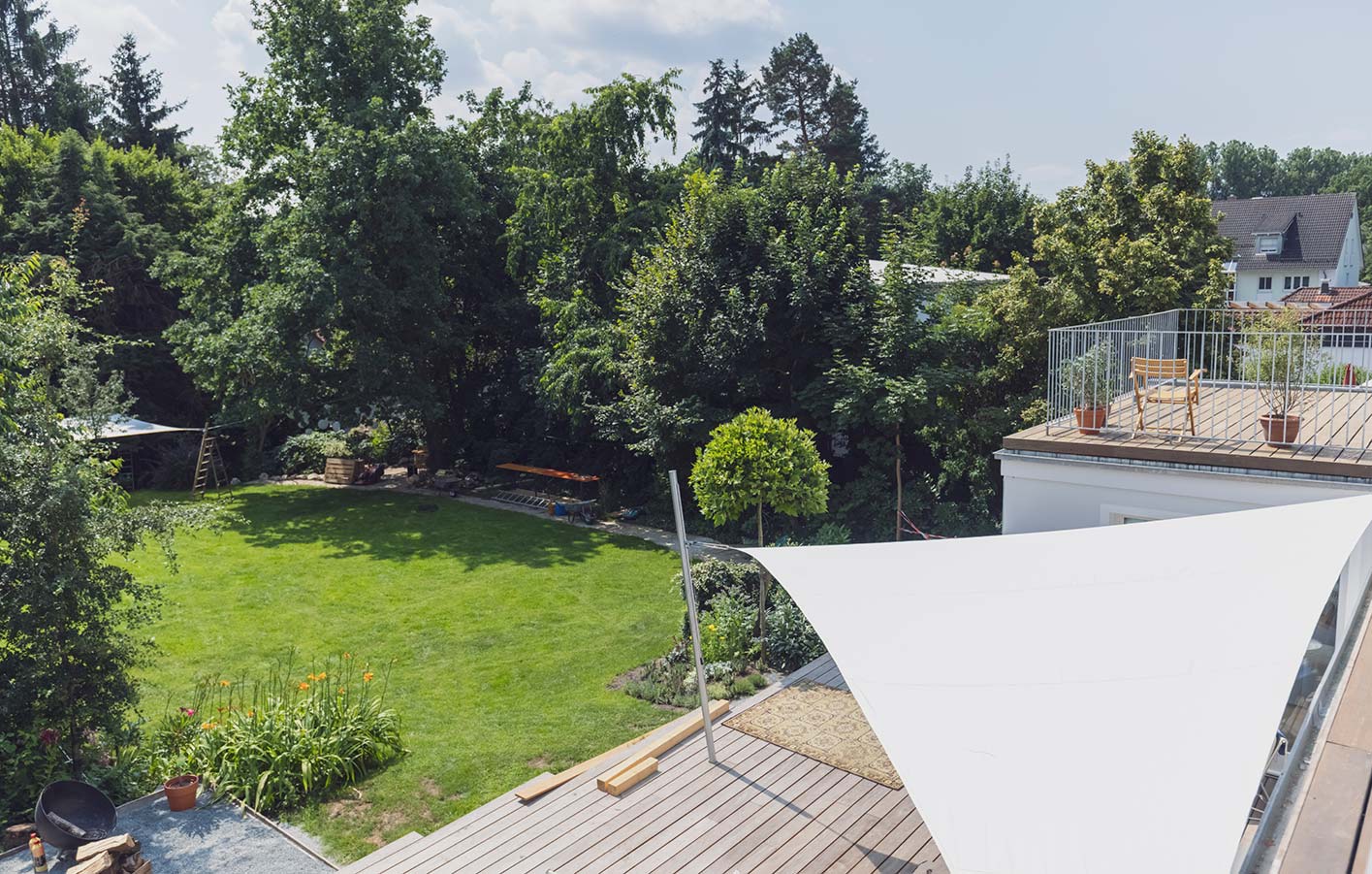 Blick von oben in einen Garten und auf Terrasse - geschützt durch ein Sonnensegel